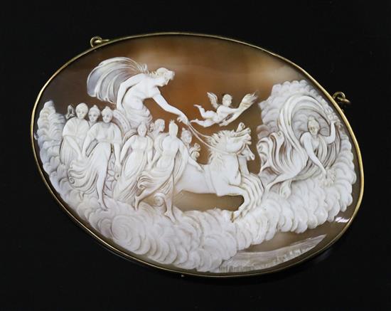 A large late Victorian gilt metal mounted oval cameo pendant brooch, carved with chariot, muses and cherub, 11.1cm.